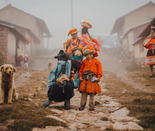 Photographer with locals in colorful traditional attire in a Peruvian village