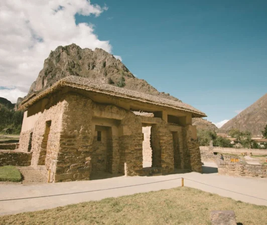 Explore the stone ruins against majestic mountains in Ollantaytambo, Peru.